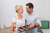 Happy couple preparing cookies together in kitchen
