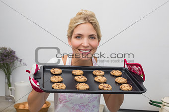 Smiling woman with a tray of cookies in the kitchen