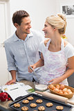 Happy young couple preparing cookies in kitchen