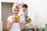Couple with young potted plants in the kitchen