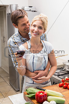 Portrait of a loving couple with wine glass in kitchen