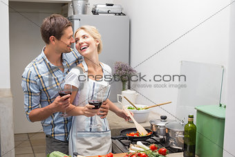 Loving young couple with wine glass in kitchen