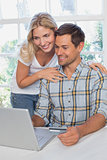 Happy couple doing online shopping at home