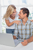 Smiling young couple doing online shopping at home