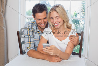 Couple reading text message together at home