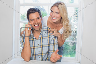 Happy man on call besides a beautiful woman