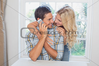 Man on call besides a beautiful woman at home