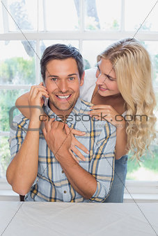 Man on call besides a beautiful woman at home