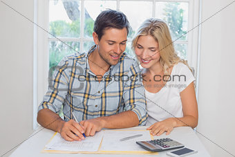 Couple with financial documents and calculator at home