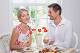 Happy couple with wine glasses having food