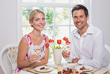 Happy young couple with wine glasses having food