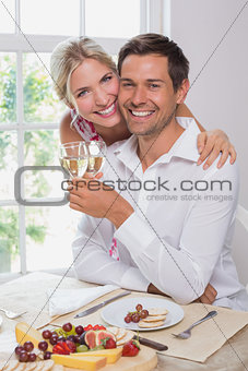 Happy young couple with wine glasses having food