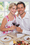 Loving young couple with wine glasses at dining table