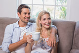 Relaxed loving couple with coffee cups in living room