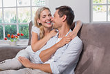 Relaxed loving young couple sitting on sofa