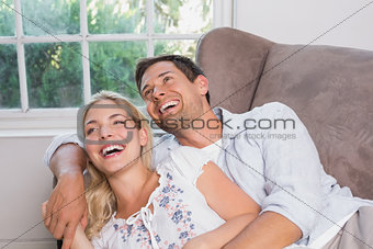 Casual young couple laughing in living room