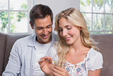 Happy young couple looking at flower in living room