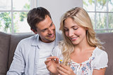 Happy couple looking at flower in living room