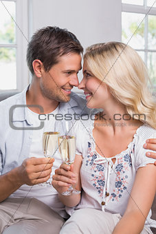 Loving couple with champagne flutes at home
