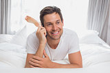 Casual relaxed man using mobile phone in bed