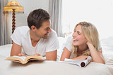 Relaxed casual couple reading books in bed