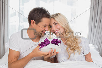 Beautiful blonde receiving a gift box in bed