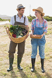 Full length of couple with vegetables in field