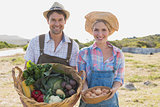 Smiling couple with vegetables in field