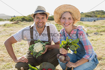 Smiling couple with fresh vegetables in field