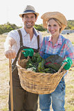 Smiling couple with fresh vegetables in field