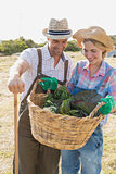 Couple with fresh vegetables in field
