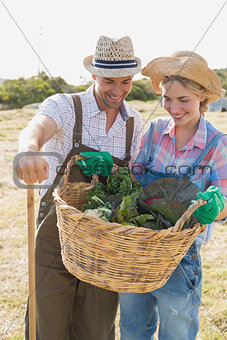 Couple with fresh vegetables in field