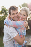 Portrait of a smiling couple embracing in park