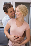 Man embracing woman from behind at home