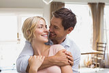 Man embracing woman from behind at home