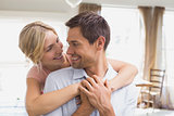 Woman embracing man from behind at home