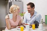 Couple looking at each other while having breakfast at home