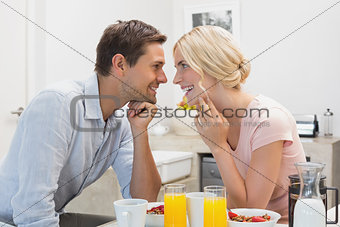 Happy couple having breakfast at home