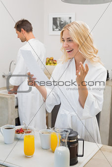 Smiling woman looking at document with man in kitchen