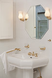 Mirror with lit lamps over sink in bathroom