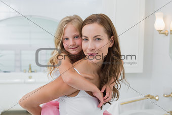 Woman carrying young girl in the house