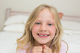 Portrait of a happy young girl resting in bed