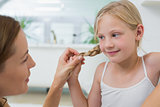 Close-up of a woman adjusting cute little girl's hair