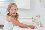Portrait of a cute girl washing hands at washbasin