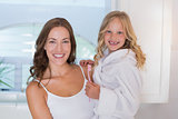 Smiling mother and daughter with toothbrush