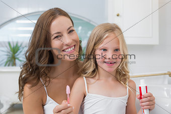 Mother and daughter with toothbrush and toothpaste