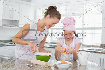 Girl helping her mother prepare food in kitchen
