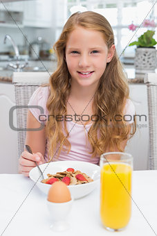 Young girl having breakfast in kitchen