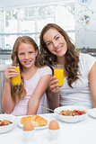 Mother and daughter having breakfast in kitchen