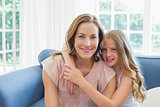Happy daughter embracing mother in living room